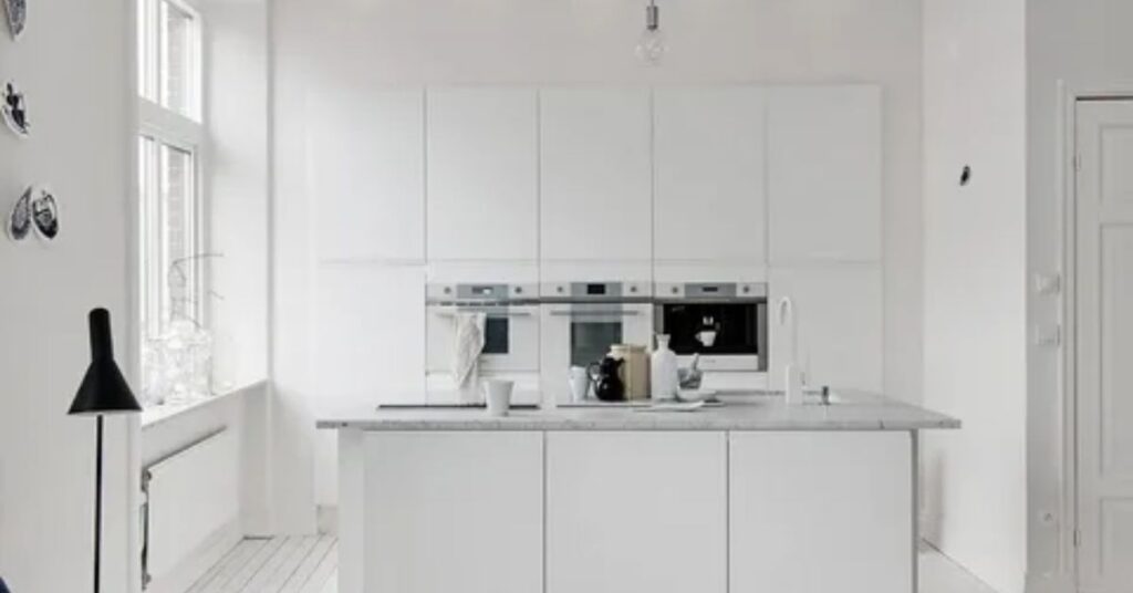 A Minimal White Kitchen With a Full-Length Floating Shelf